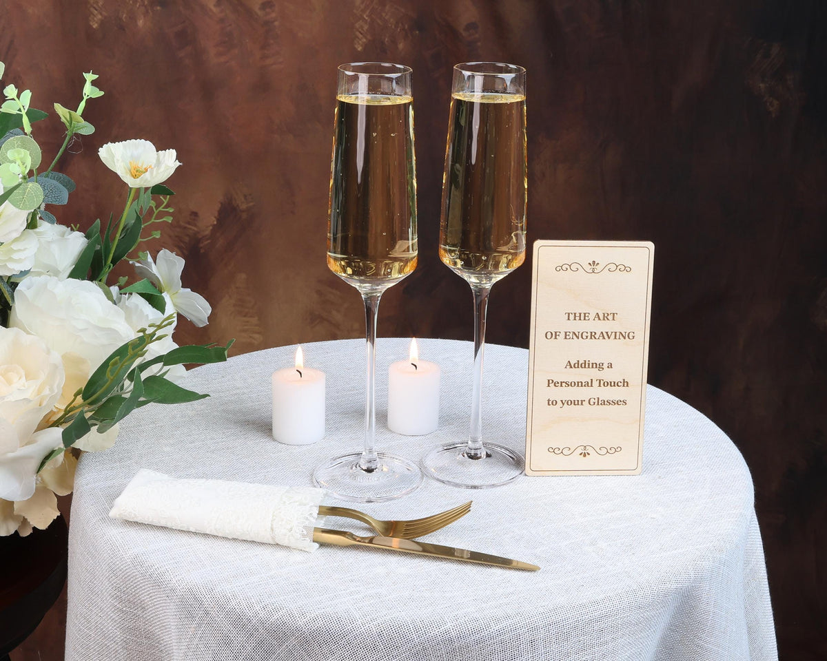 two glasses of champagne sitting on a table with a sign