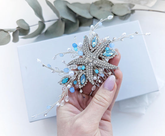 a person holding a brooch with a flower design on it