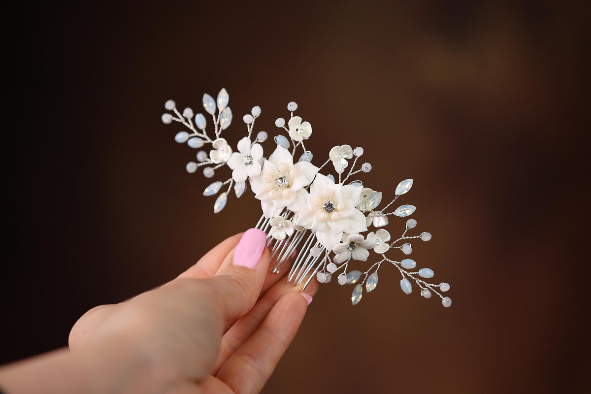 a hand holding a hair comb with flowers on it