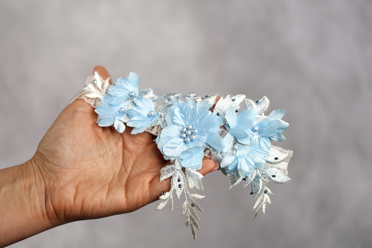 a hand holding a bunch of blue flowers