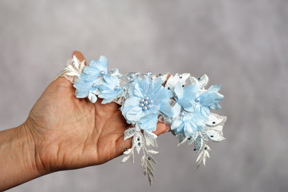 a hand holding a bunch of blue flowers