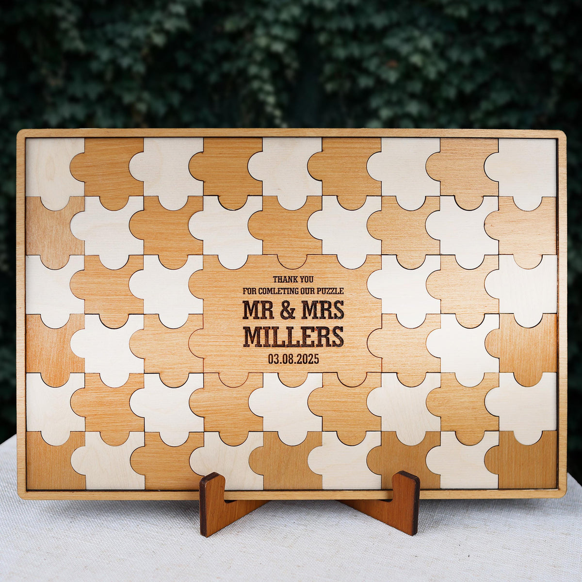 A wooden puzzle frame with a message engraved on it, placed on a stand.