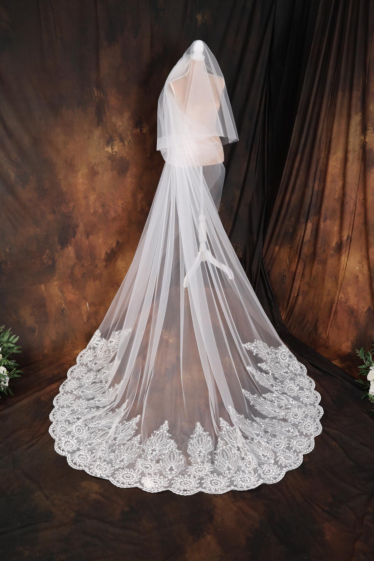 a wedding veil with a lace edge on a mannequin