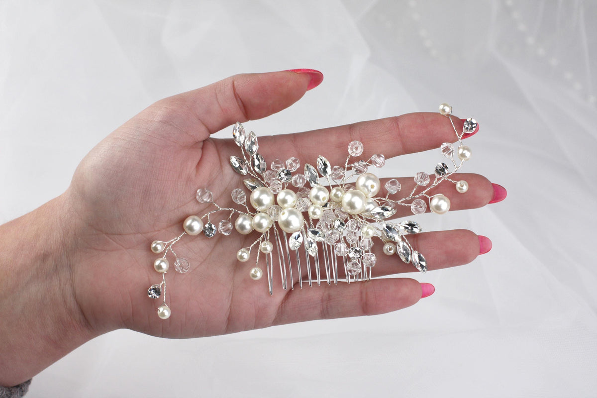 a woman's hand holding a bridal hair comb