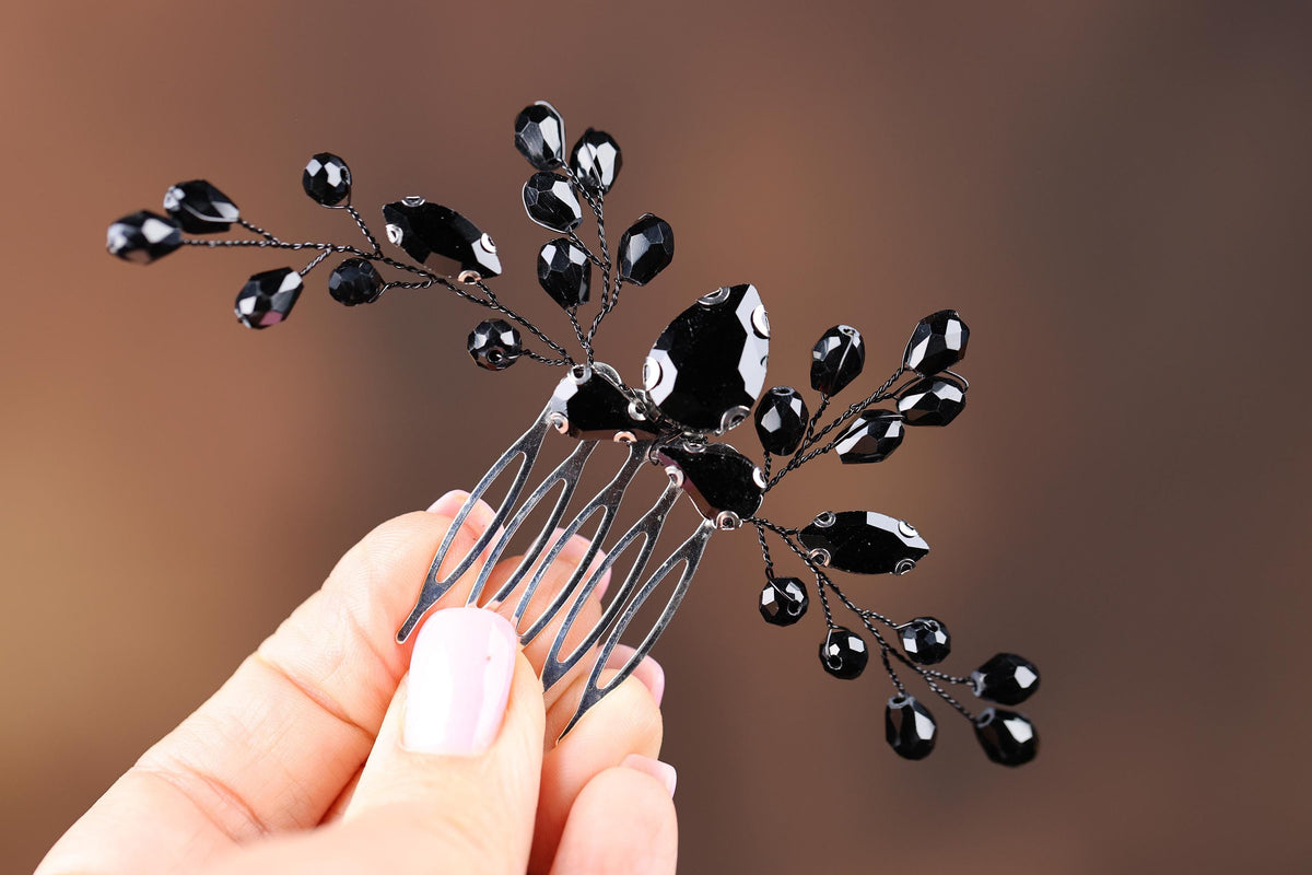 a hand holding a black and white hair comb