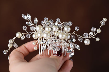 a hand holding a bridal hair comb with pearls and crystals