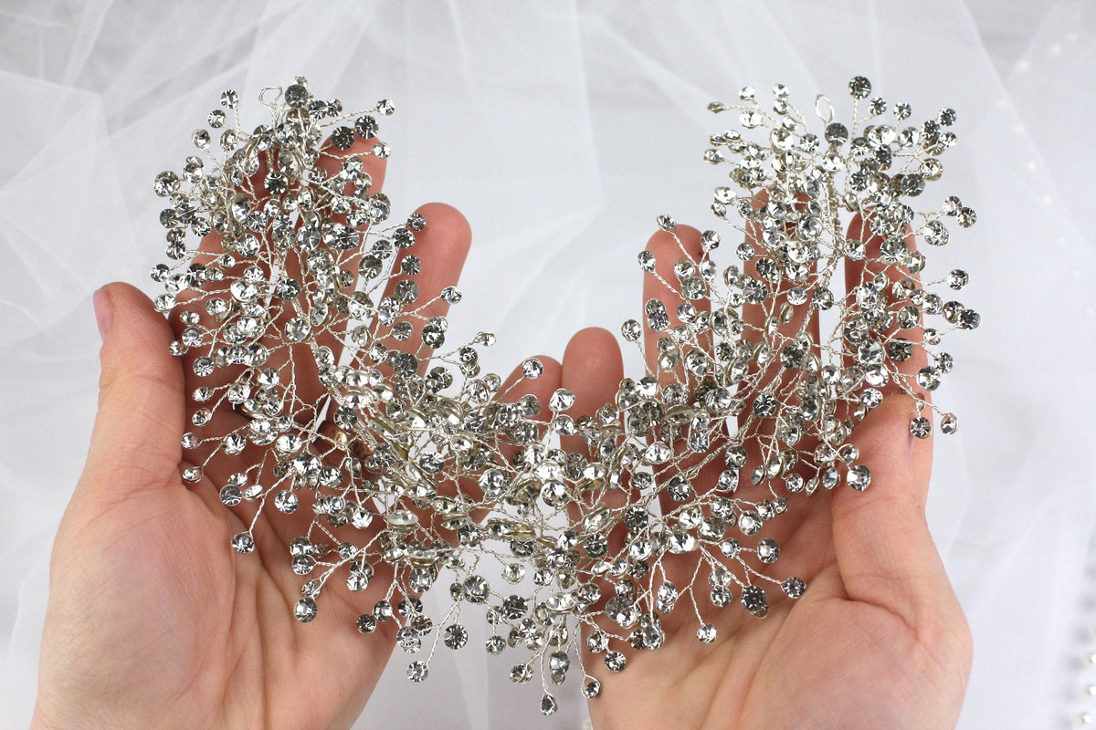 a pair of hands holding a wedding brooch