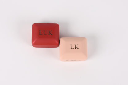 Two square boxes, one red and one pink, with the letters "LUK" printed on them.