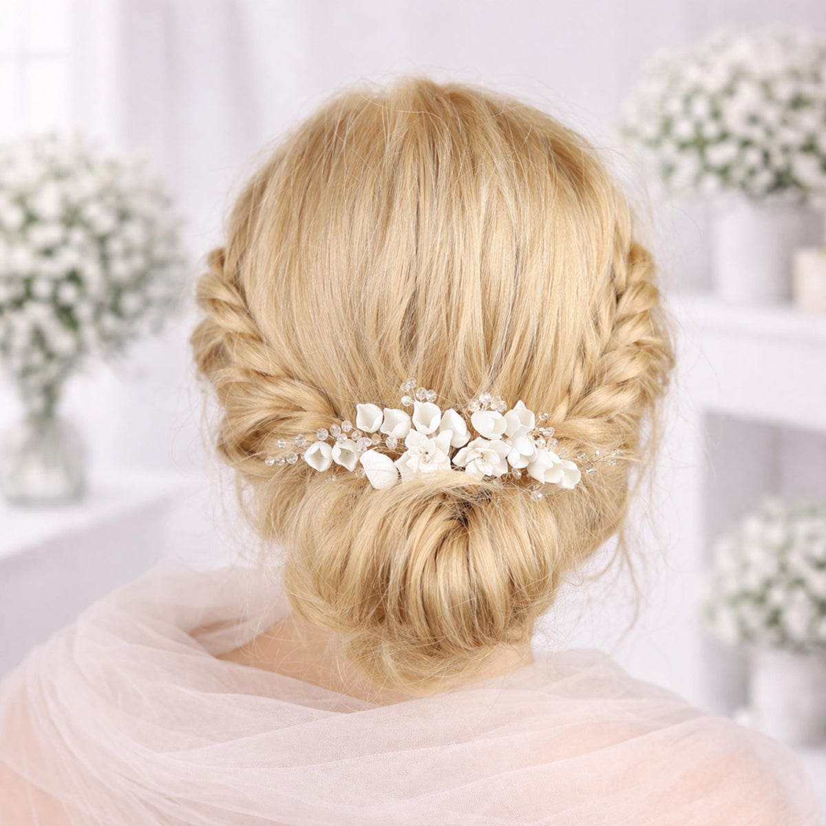 a woman's blonde hair styled in a bun with a decorative flower accessory, likely a veil or hairpiece, in the background.