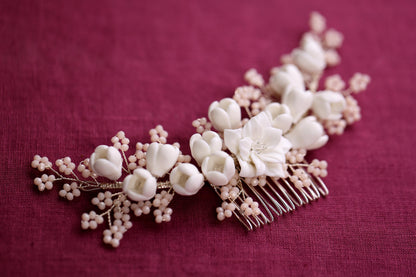 a hair comb with white flowers on it