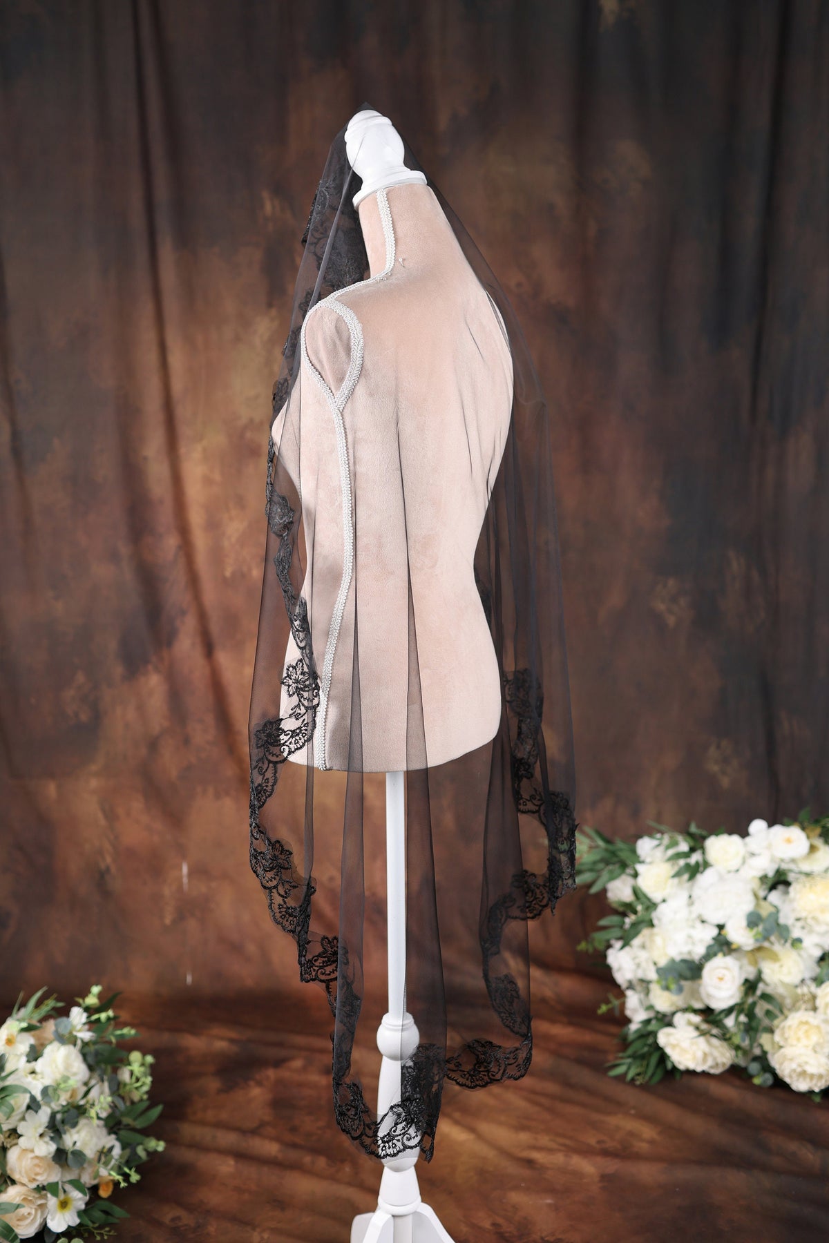 a white mannequin with a black veil on top of it