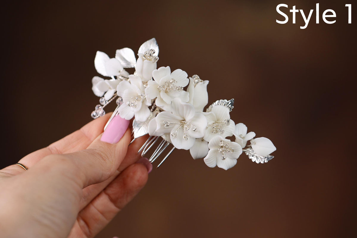 a hand holding a white flower and a hair comb