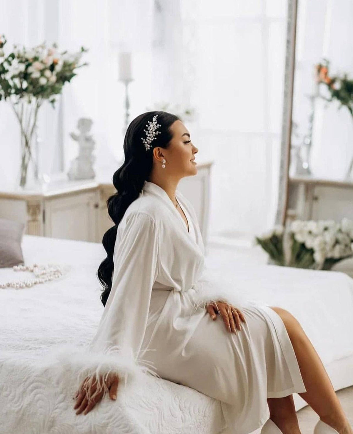 a woman in a white dress sitting on a bed