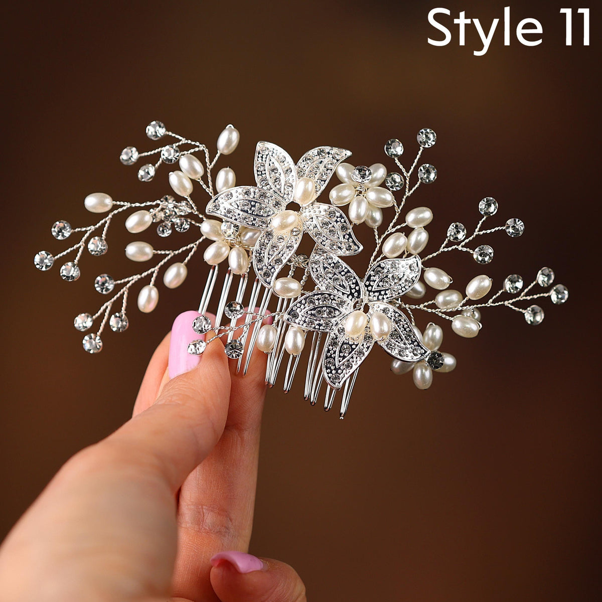 A hand holding a decorative hair accessory with a floral design and sparkling crystal elements.