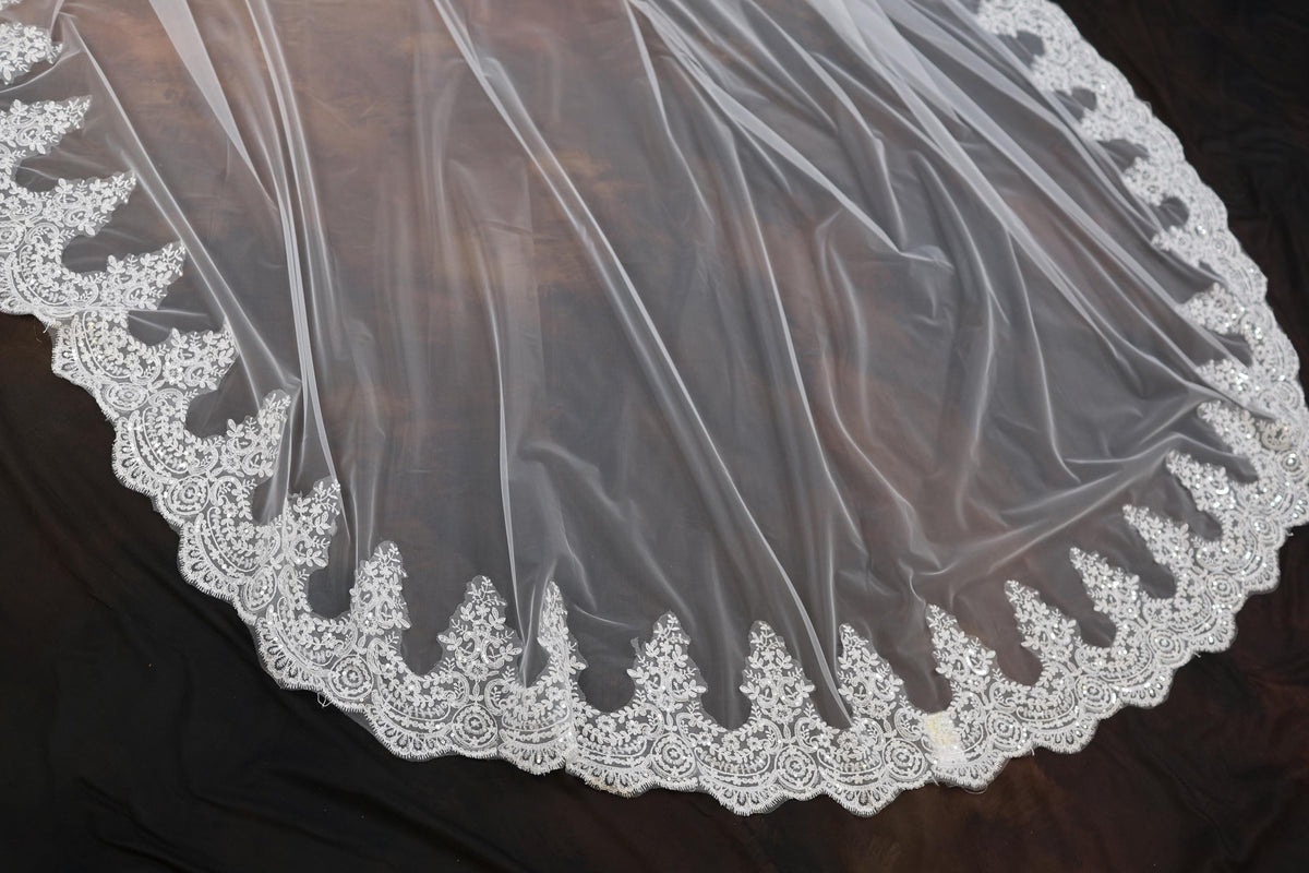 a wedding veil with a lace edge on a black background