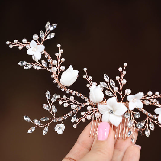 a woman's hand holding a hair comb with flowers on it