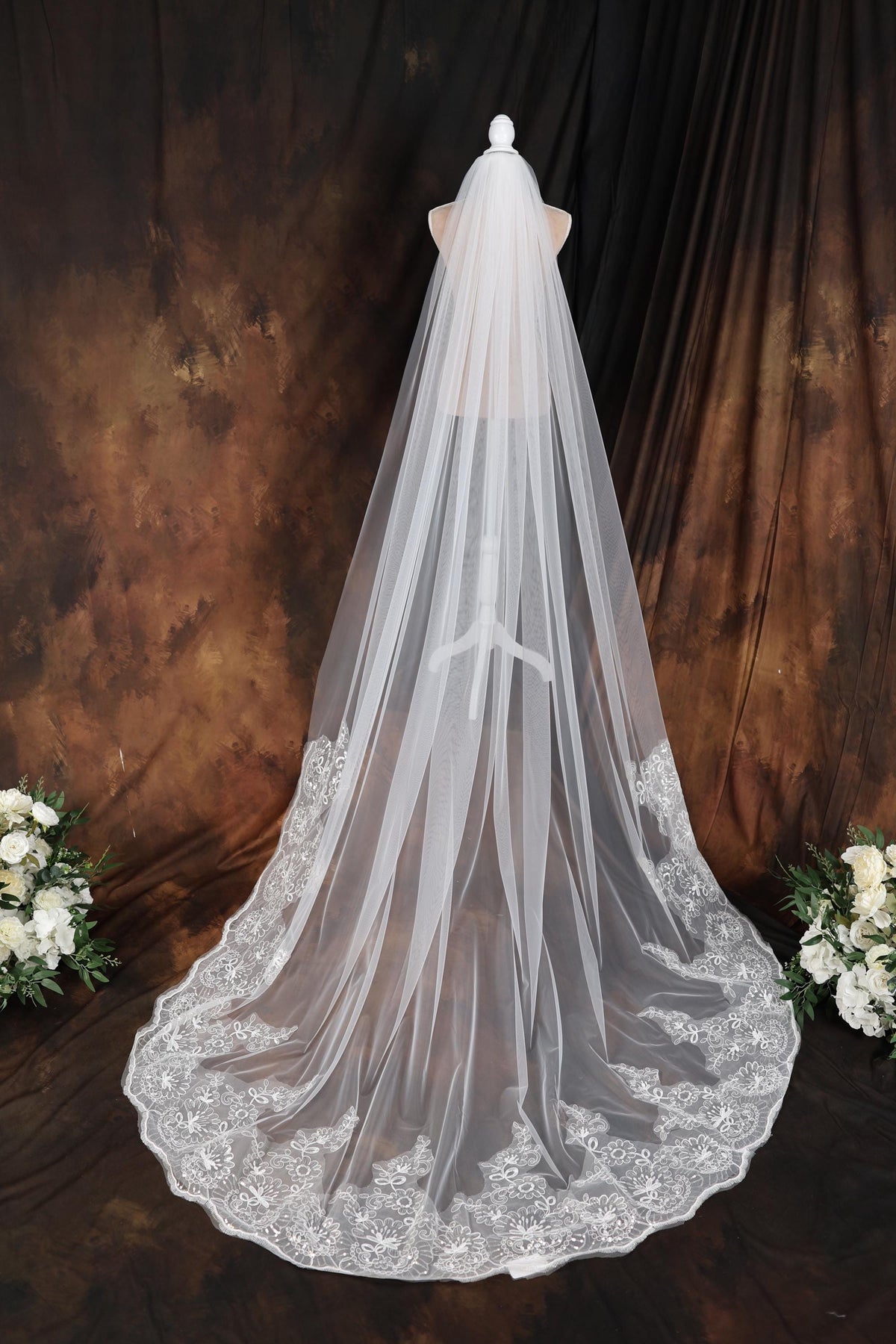 a bridal veil with white flowers on it