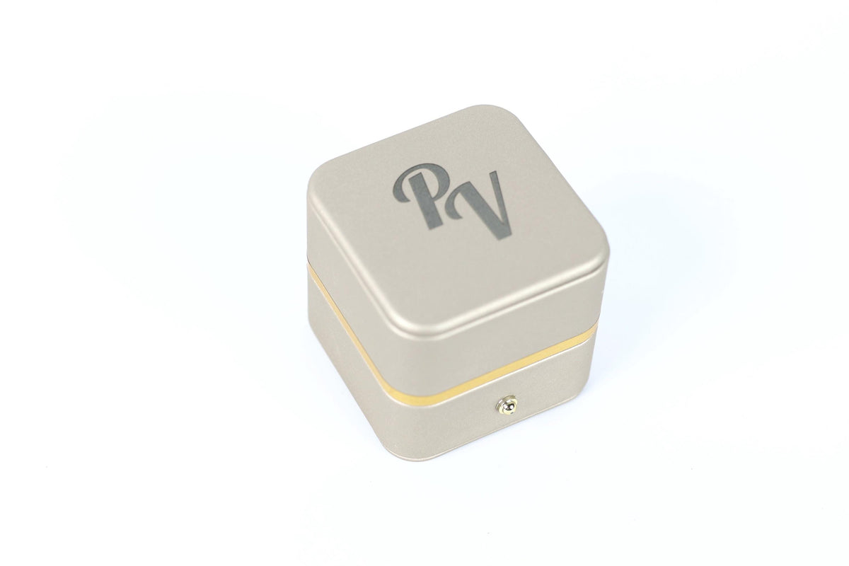 A square metal box with a logo on it, placed on a white background.