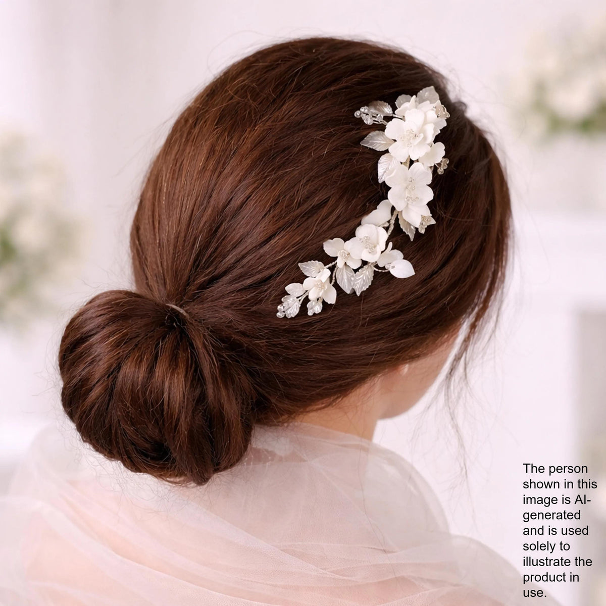A woman with her hair styled in a bun, wearing a white flower accessory.