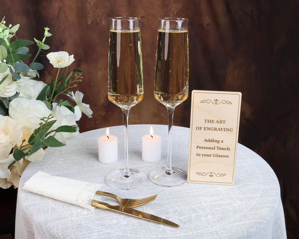 two glasses of champagne sitting on a table with a sign