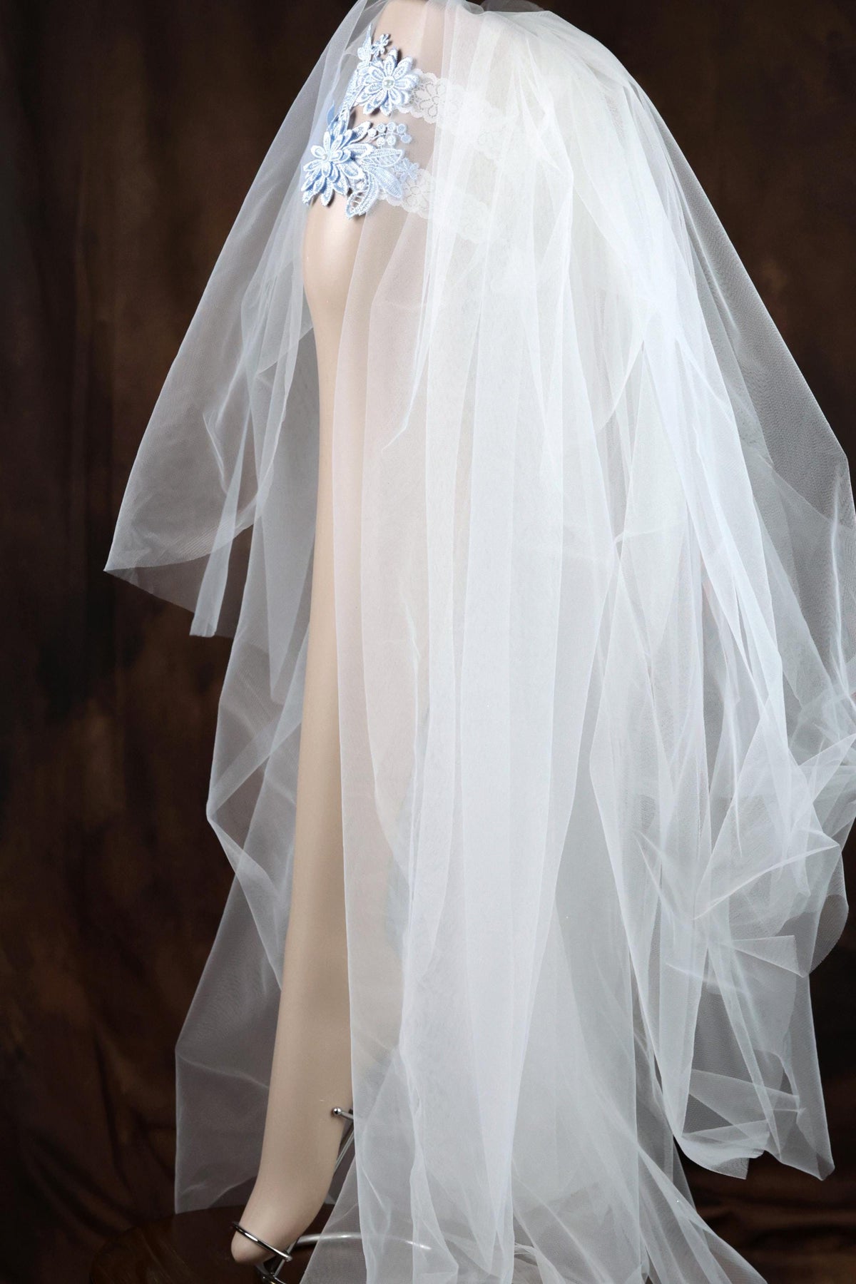 A mannequin wearing a white wedding dress with a long, flowing veil.