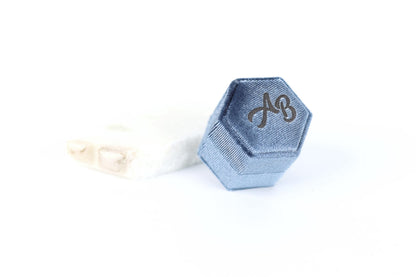 A blue hexagonal box with the letters "AB" printed on it, placed on a white surface.
