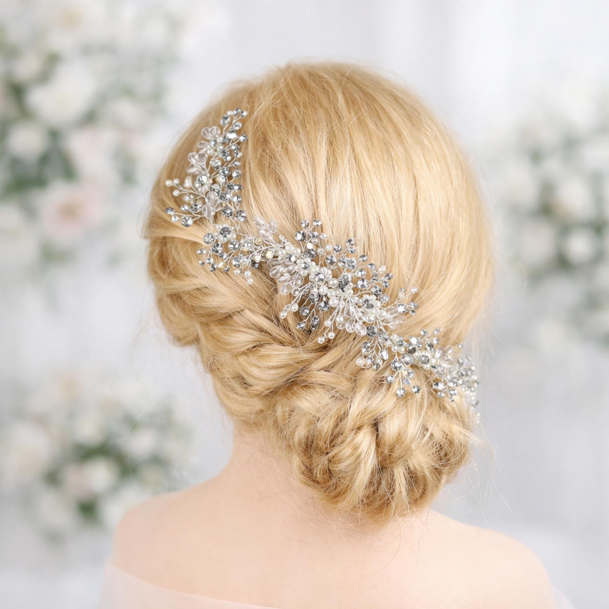 A close-up of a woman's blonde hair with a decorative hair accessory, possibly a headband or hairpiece, in the background.