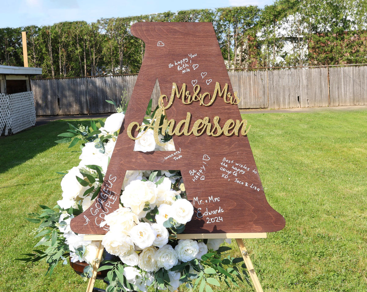 a wooden sign with flowers and writing on it