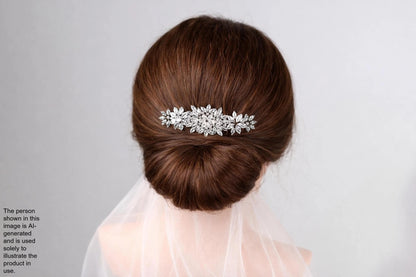 the back view of a woman's head with a decorative hair accessory, specifically a silver floral hair clip, attached to her hair.