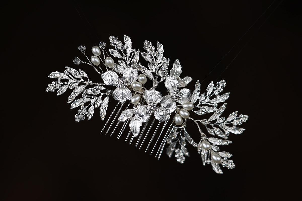 a close up of a hair comb with pearls and leaves