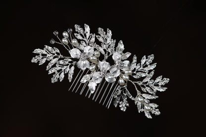 a close up of a hair comb with pearls and leaves