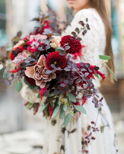 a woman is holding a bouquet of flowers