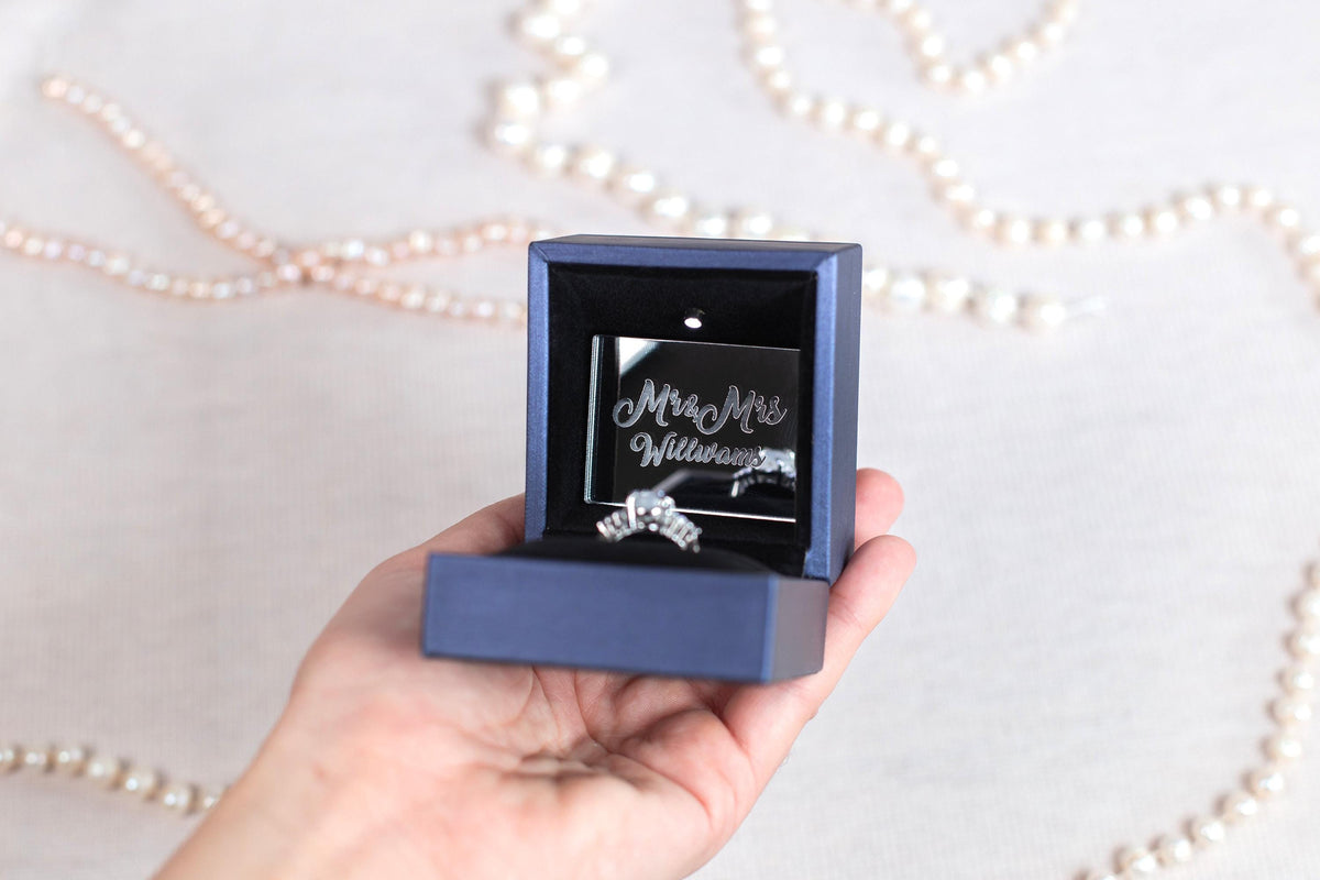 a person holding a ring in a box