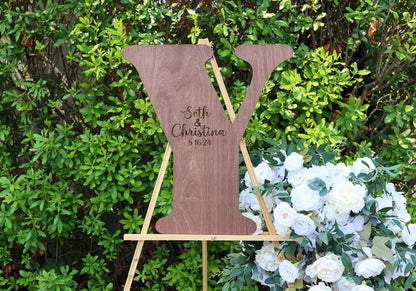 a wooden sign sitting next to a bouquet of flowers