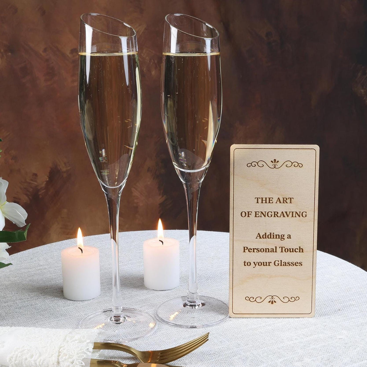 a table with two glasses of champagne and a sign