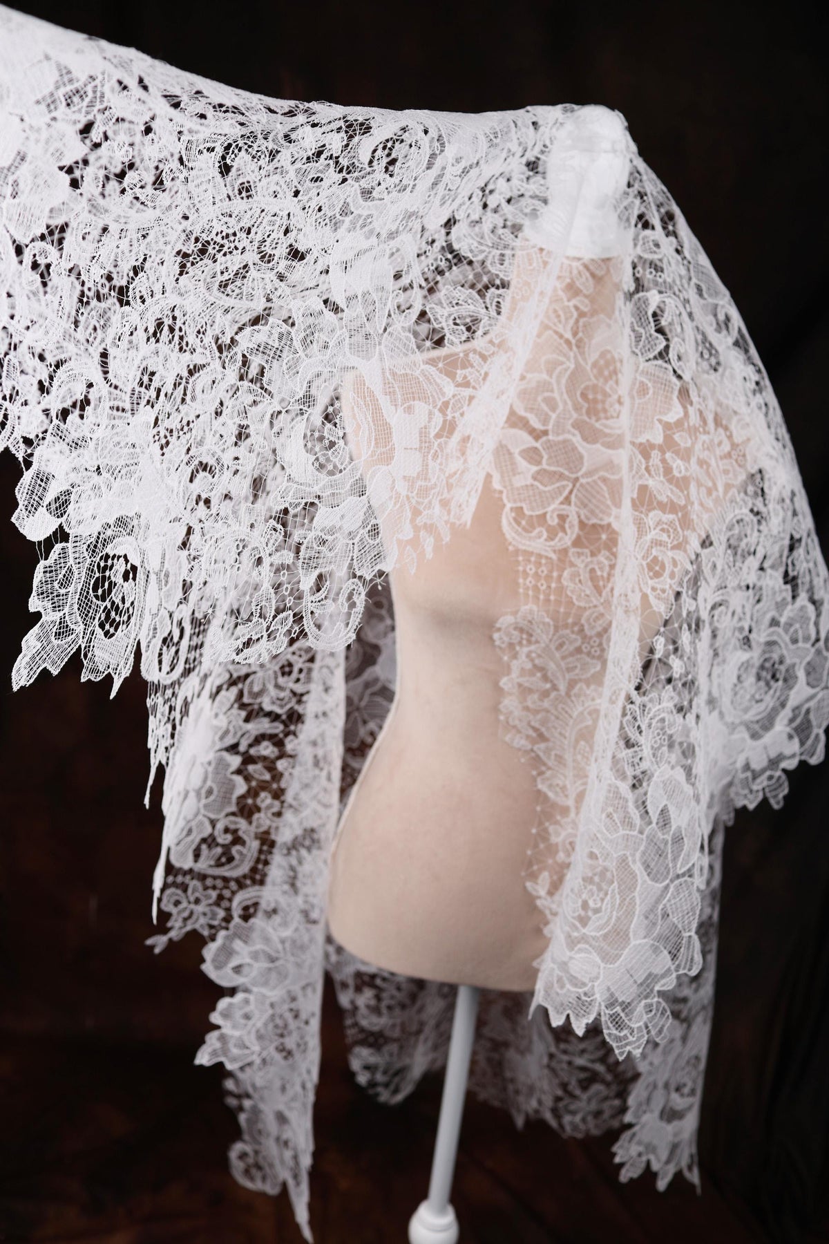a mannequin wearing a white lace shawl