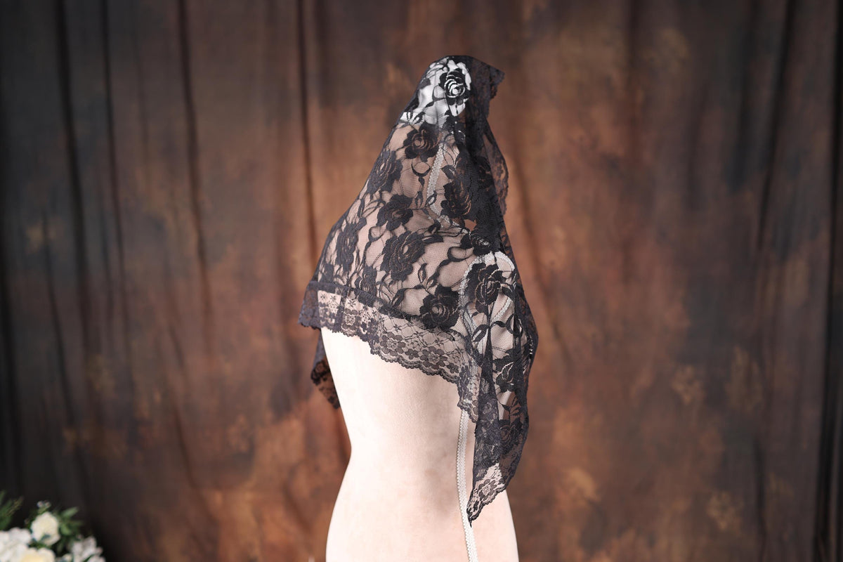 a mannequin wearing a black lace dress