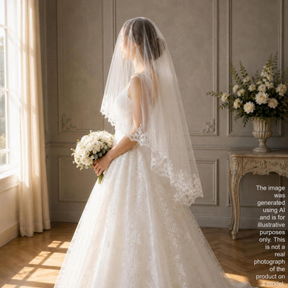A bride in a white lace wedding dress stands in a room with a large window, holding a bouquet of white flowers and wearing a veil.