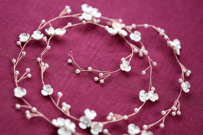 a close up of a necklace with flowers on it