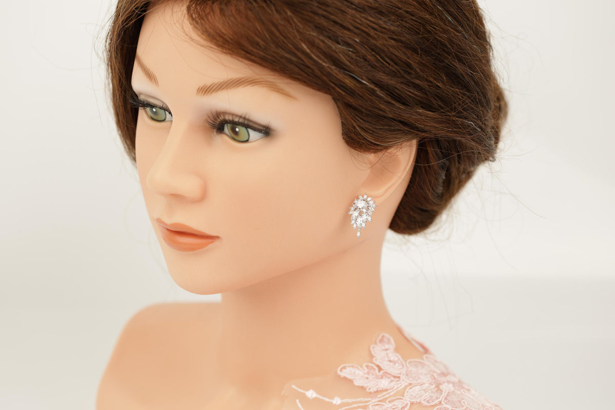 A close-up of a woman's face wearing a pair of earrings with a floral design.