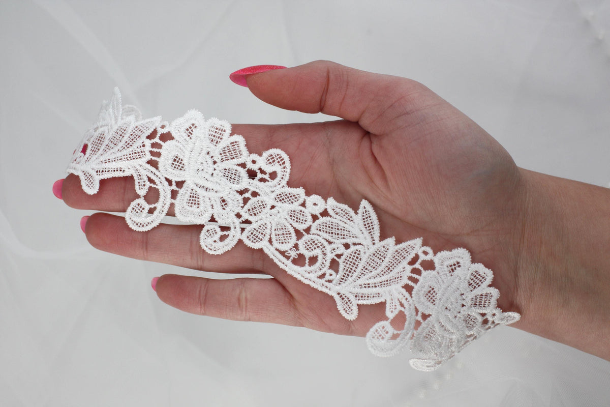 a woman's hand holding a piece of white lace