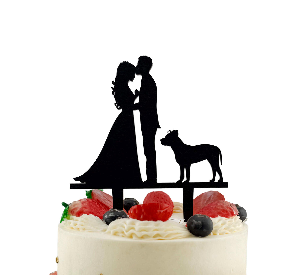 A silhouette of a bride and groom on top of a cake, with a dog silhouette in the background.