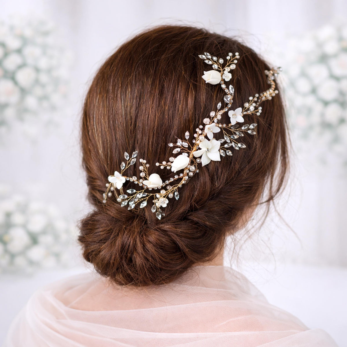 the back view of a woman's head with a hair accessory featuring white flowers and gold accents.