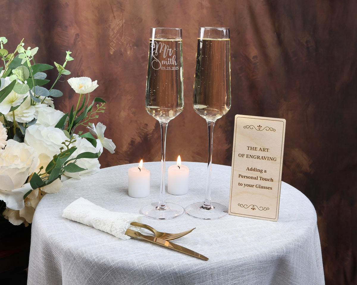 a table with two glasses of wine and a sign on it