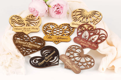 a collection of heart-shaped wooden tags with various designs and text, placed on a white surface.