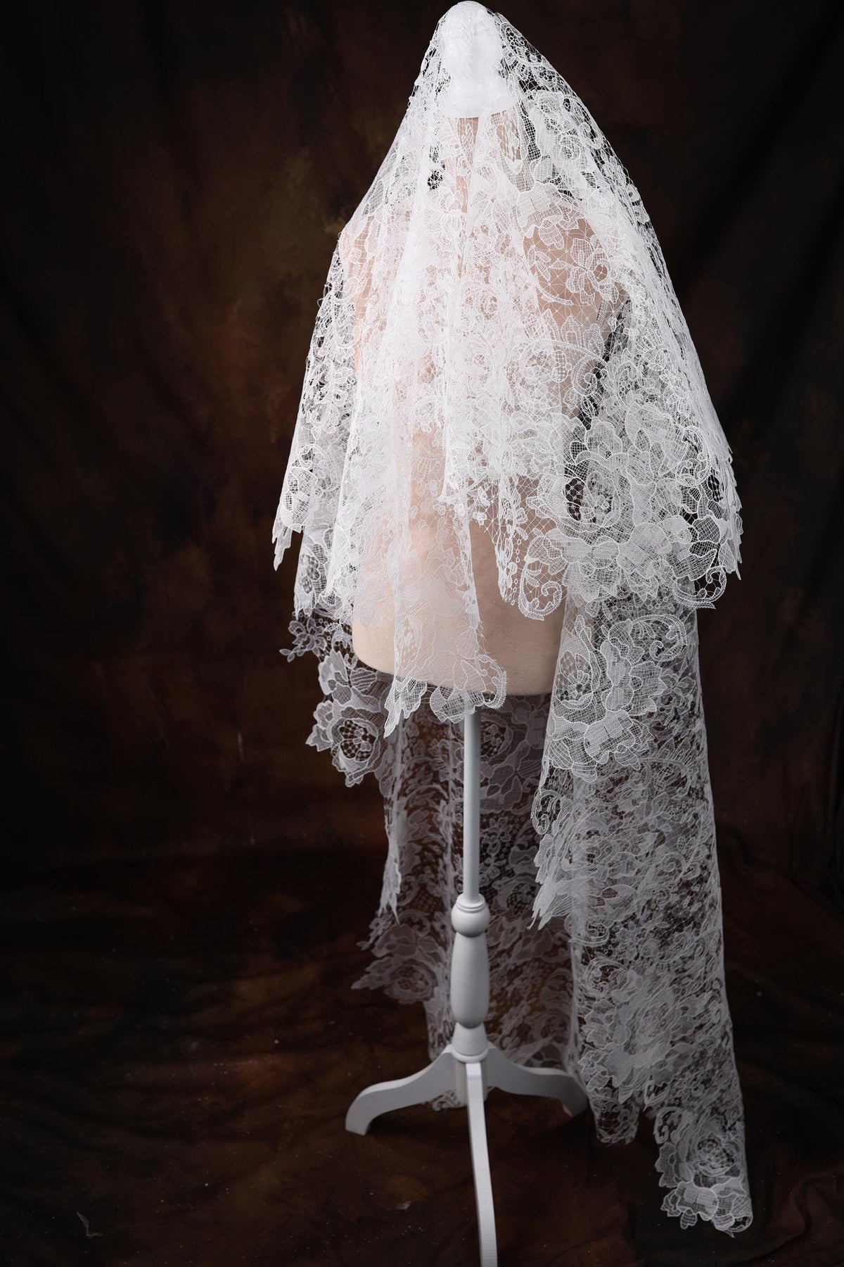 a mannequin wearing a white veil on a black background