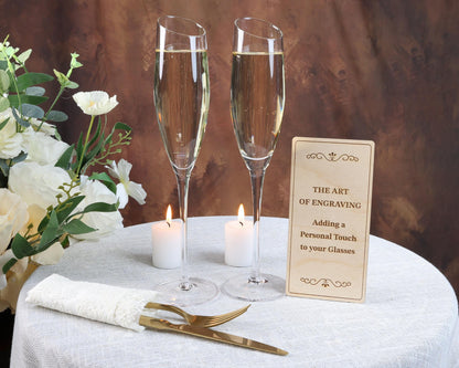 a table with two glasses of champagne and a sign