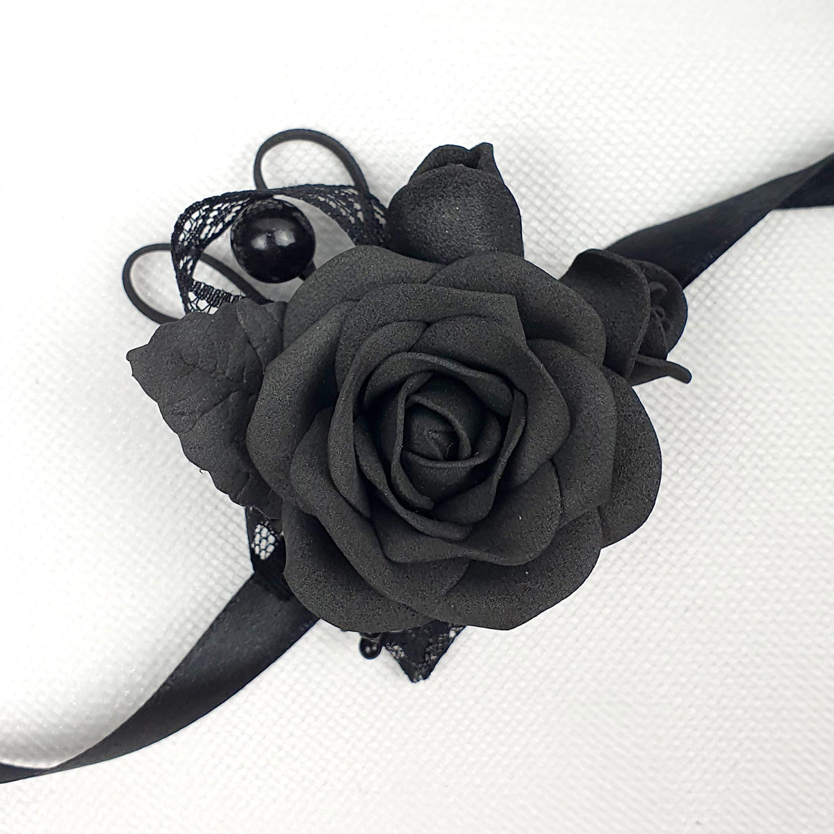 a black corsage with a black rose on it