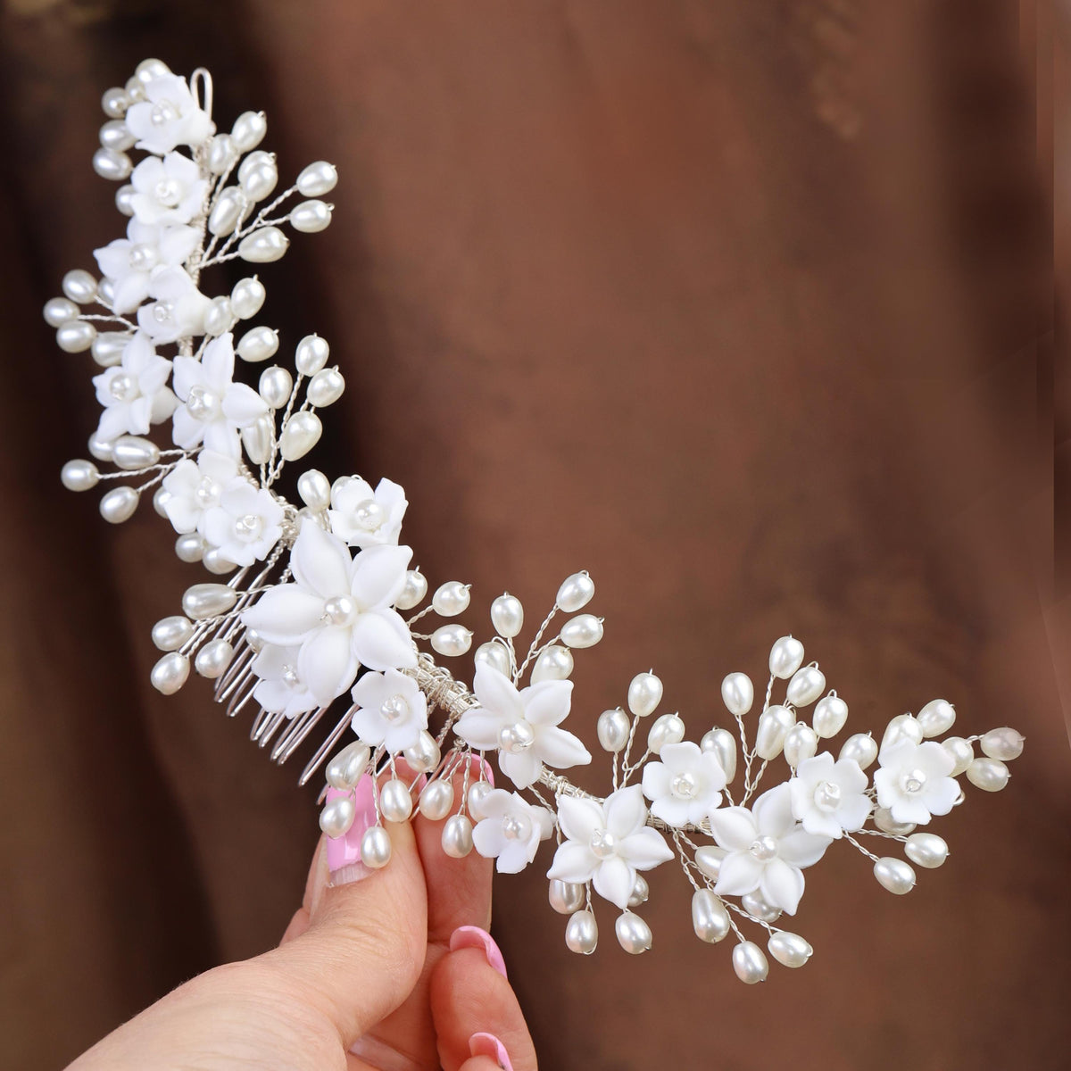 a woman is holding a bridal hair comb