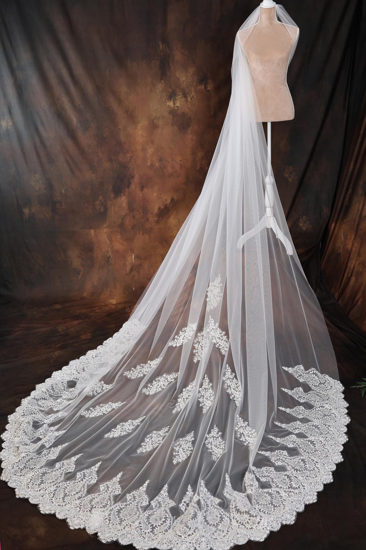 a wedding veil with a lace edge on a mannequin